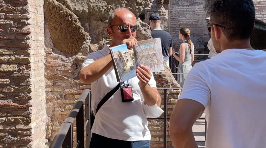 local tour guide, expert roman historian and author, max francia, explains the colosseum underground with the aid of his own book
