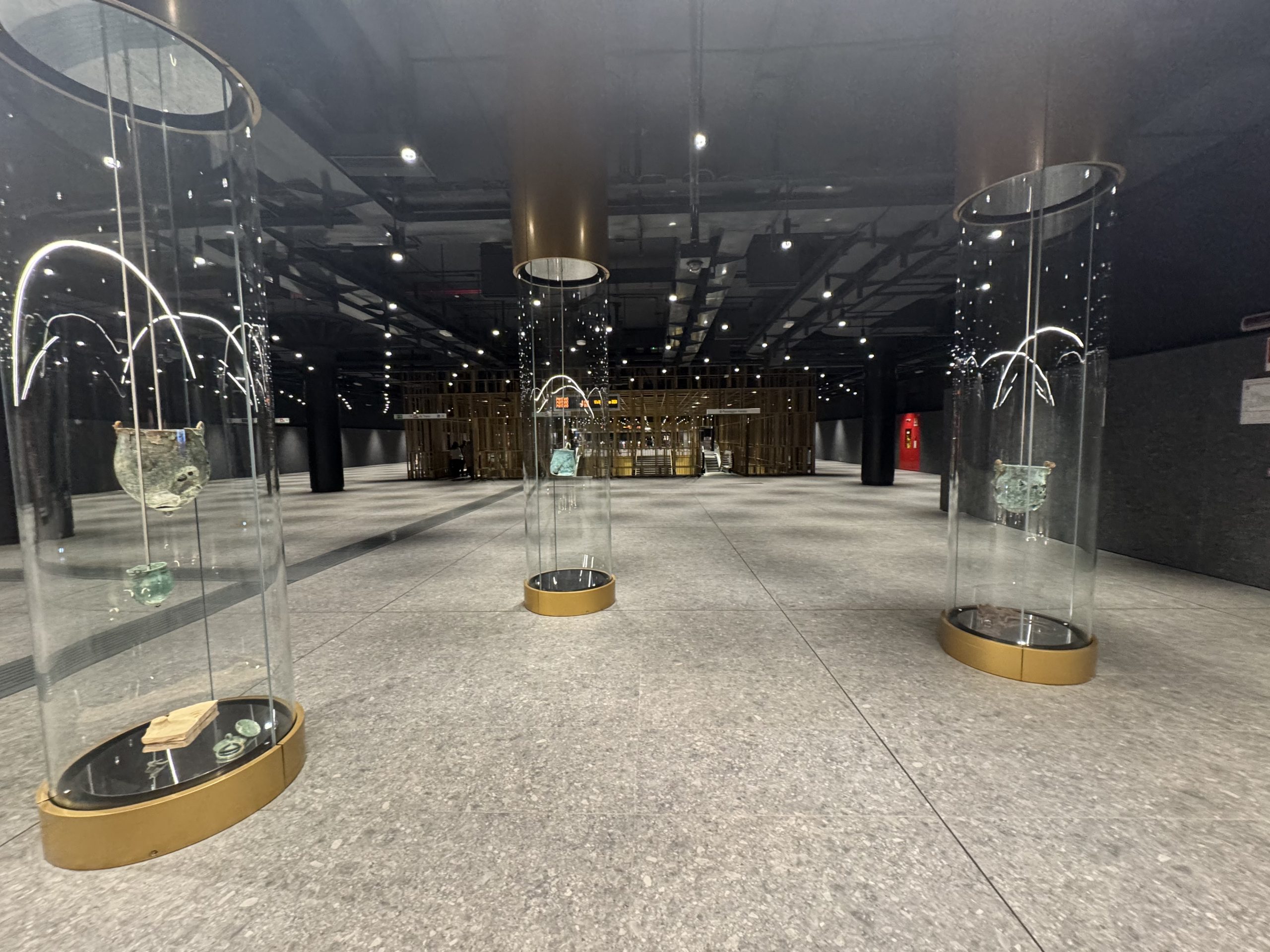 Glass display cylinders with ancient artefacts inside a modern Rome metro station.